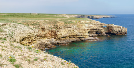 Fototapeta premium Rocky sea coast with steep textured limestone cliff