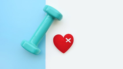 Sport and fitness concept background with red heart and dumbbells for background