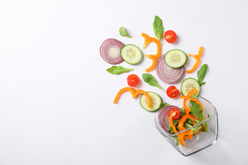 Glass bowl with fresh vegetables slices on white background, copy space