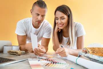 Happy young couple choosing color of walls in their new house