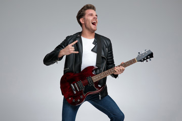 casual man playing his guitar passionate