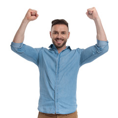 casual man standing with hands up happy