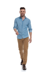 Fototapeta premium casual man walking with hand raised happy