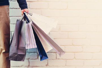 Sale, discount, black friday concept. Man with bunch of shopping bags. Copy space. Shopping mall...