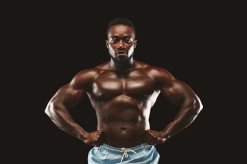 Fototapeta na wymiar Confident afro guy demonstrating his muscular chest