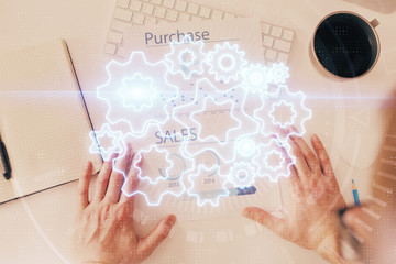 Double exposure of hands and notepad with business icons.