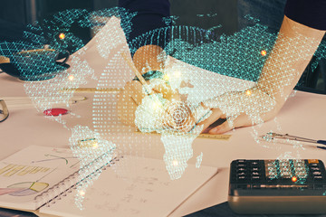 Double exposure of hands and notepad with business icons.