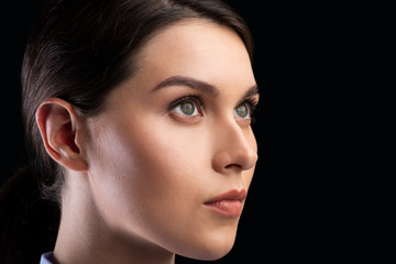 Fototapeta premium Portrait Of Female Face Staring Aside Over Black Background