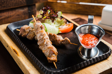 Grilled shish kebab with vegetables on black.