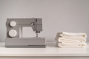 sewing machine with white towels on tailor table with copy space