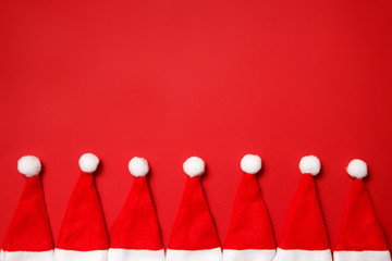 Christmas and New Year holiday background. Santa hats on a red background. Place for text