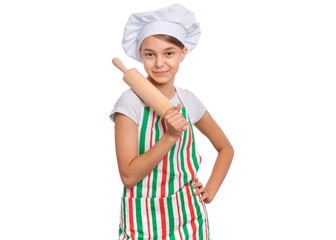 Portrait of beautiful teen girl in chef hat holding rolling pin, isolated on white background. Portrait of cute smiling child cook in apron with wooden rolling pin. Tools and equipment for cooking.