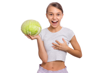 Beautiful young teen girl holding fresh green cabbage and looks at her breast, isolated on white background. Surprised child with healthy raw vegetables in hands. Organic natural healthy food produce. - 291436033