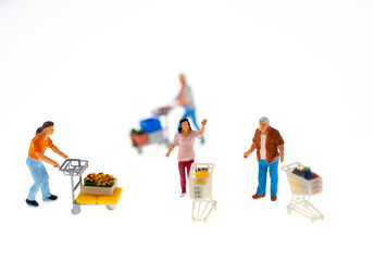 miniature people shopping in markets with sale items containing in shopping carts. they greet shoppers happily. this image for happy shopping and business concept