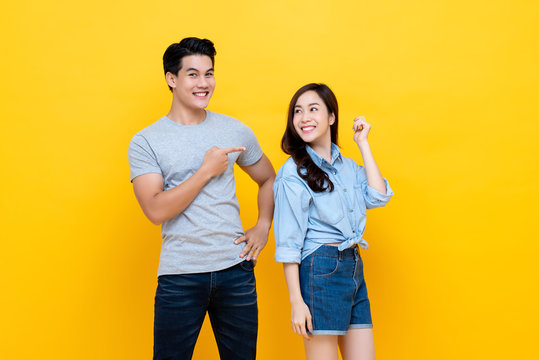 Asian handsome man pointing finger at smiling woman