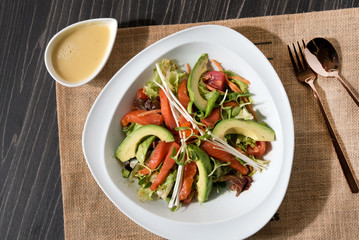 Smoked salmon with mixed lettuce, avocado, capers, and onion