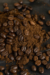 Naklejka premium Coffee beans and ground powder on black marble background. Top view 