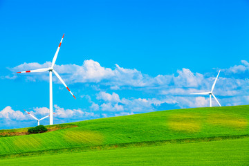 Fototapeta na wymiar Wind electricity generators in spring fields.