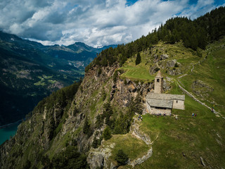 Fototapeta na wymiar church/chapel close to cliff drop-off above mountain valley