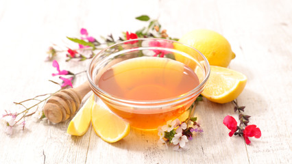 bowl of honey with lemon and flowers