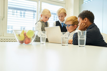Gruppe Kinder als Business Team am Laptop