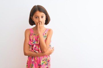 Young beautiful child girl wearing pink floral dress standing over isolated white background looking stressed and nervous with hands on mouth biting nails. Anxiety problem.