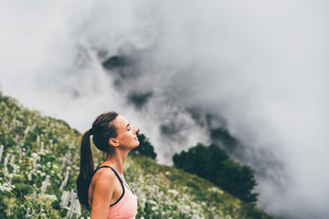 Woman meditating on mountain cliff above the clouds. Alone travel healthy lifestyle. Healthy life...