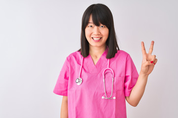 Young beautiful Chinese nurse woman wearing stethoscope over isolated white background showing and pointing up with fingers number two while smiling confident and happy.