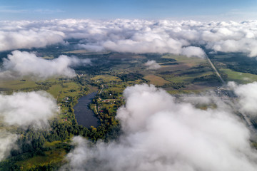Fototapeta premium Beautiful views of the countryside from a great height. Flying above the clouds.