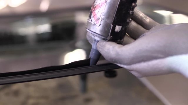 Car Repair Service. Worker Using Silicone For Fitting A New Car Windshield 