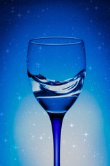 wine glass of flying water on blue background