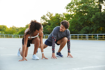 Photo of multinational attractive couple doing exercise together