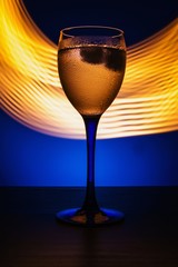 wine glass with water on a blue background with luminous lines