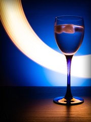 wine glass with water on a blue background with luminous lines