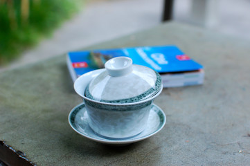 Close-up of cup of tea on the table in China, background whit touristic guide out of focus