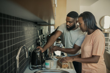 Young African American couple preparing breakfast in their kitchen