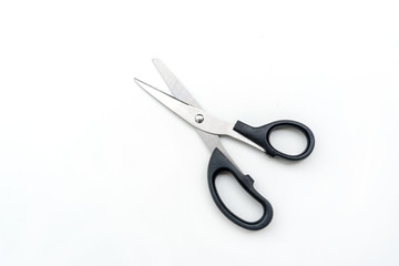 Open pair of scissors with black handle isolated on white background, top view