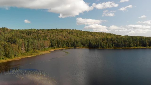 Aerial view over a beautiful still blue water lake surrounded by forest at Heisetra cabin in Kodal, Norway