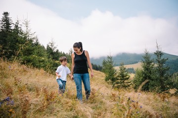 Young mom with baby boy travelling. Mother on hiking adventure with child, family trip in mountains. National Park. Hike with children. Active summer holidays.