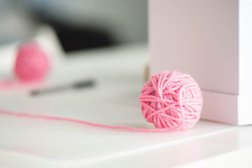 Pink yarn ball with woolen thread on white background