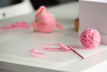 Pink yarn ball with woolen thread on white background