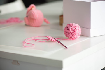 Pink yarn ball with woolen thread on white background