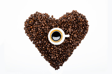 Espresso shot on roasted coffee beans heart shape on white background. Love Coffee. Coffee break. Coffee Time.