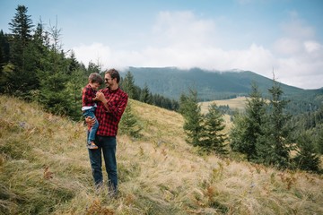 Young father with baby boy travelling. Father on hiking adventure with child, family trip in mountains. National Park. Hike with children. Active summer holidays.