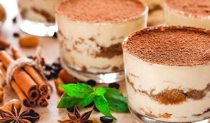 Tiramisu in the glass decorated whith mint on the wooden background