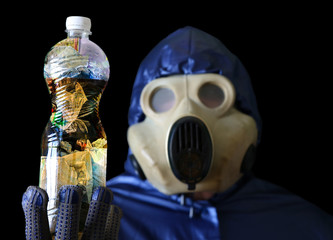 Man in the gas mask holding plastic bottle with dirty water. Environmental pollution. Ecological...