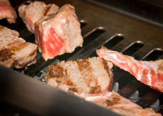 Beef meat yakiniku on a barbecue grill close up shot. 