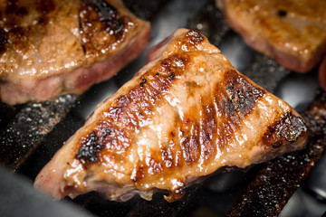 Beef meat yakiniku on a barbecue grill close up shot. 