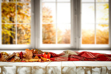 Desk of free space and autumn window background. 