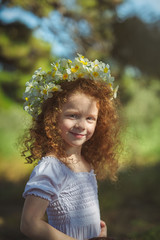 Red hair girl walking into woods with flowers.